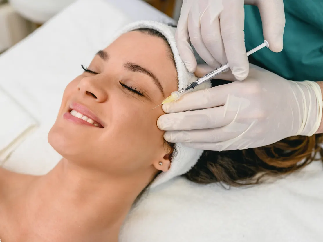 Stock photograph of models: a woman receives an injection from a gloved clinician