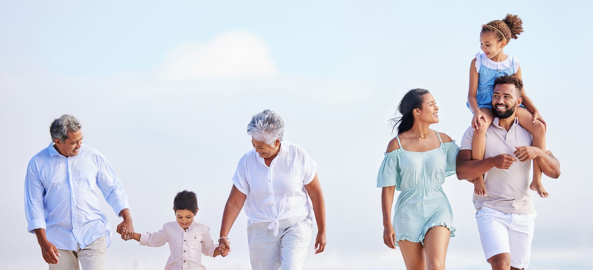 Stock photograph of models: three generations of a family walking together on a sunny beach
