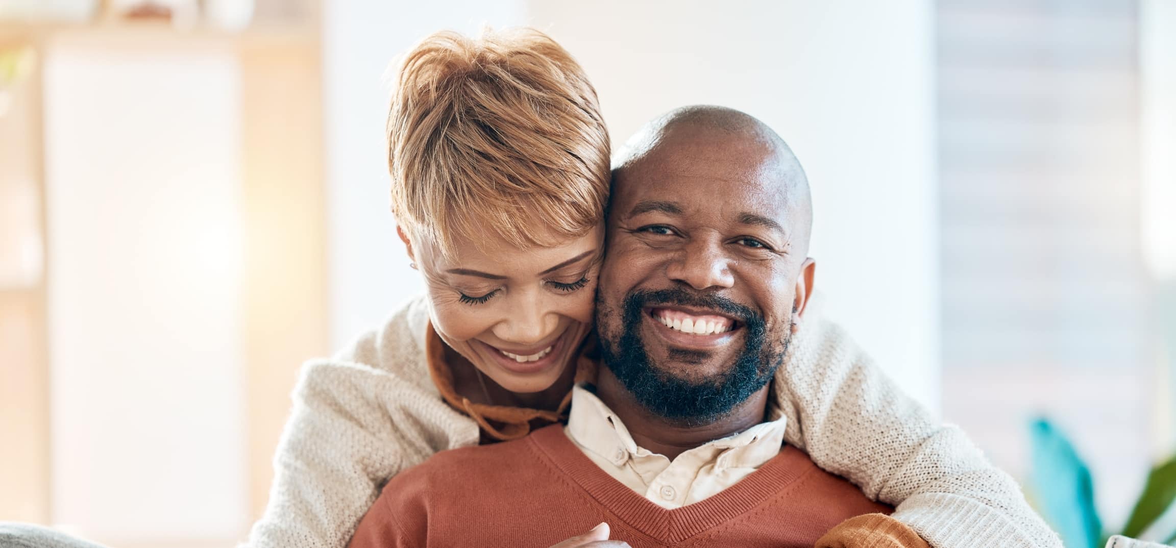 Stock photograph of models: a smiling couple embracing at home